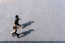 Молодая спортивная пара, бегающая вместе по городской улице — стоковое фото