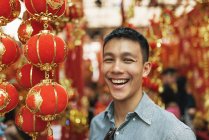 Joven feliz asiático hombre sonriendo en chinatown - foto de stock