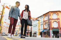 Joven feliz asiático pareja caminando en chinatown - foto de stock