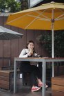 Jolie chinoise cheveux longs femme assise dans le café — Photo de stock