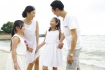 Счастливая семья, проводящая время вместе на пляже — стоковое фото