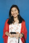 Молодая счастливая азиатка с помощью смартфона — стоковое фото