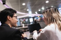 Успешная бизнес-азиатская пара вместе работает с ноутбуком в аэропорту — стоковое фото