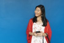 Young happy asian woman using smartphone — Stock Photo