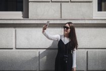 Consideravelmente chinês longo cabelo mulher tomando selfie na rua — Fotografia de Stock