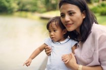 Молодая азиатская мать с симпатичной маленькой дочкой в парке — стоковое фото