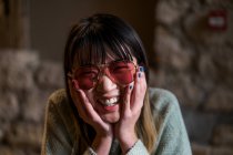 Junge lässige asiatische Mädchen lächeln in Sonnenbrille — Stockfoto