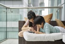 Happy young asian family together using digital tablet at home — Stock Photo