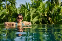 Junge asiatische Frau, die in einem Pool entspannen — Stockfoto