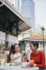 Junge asiatische Freundinnen essen zusammen im Café — Stockfoto