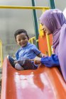 Young asian muslim mother and child playing at playground — Stock Photo