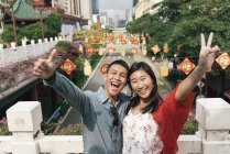 Joven feliz asiático pareja gesto en chinatown - foto de stock