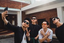 Young asian rock band posing together for selfie — Stock Photo