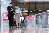 Exitoso negocio asiático pareja juntos en aeropuerto - foto de stock
