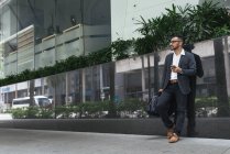 Красивий індійський бізнесмен використовує смартфон на міській вулиці — стокове фото
