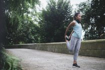 Giovane asiatica donna sportiva fare stretching nel parco — Foto stock