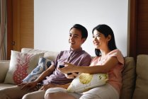Adulte asiatique couple ensemble regarder la télévision à la maison — Photo de stock