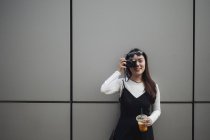 Jolie femme chinoise cheveux longs prenant des photos avec appareil photo — Photo de stock