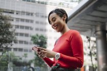 Young asian attractive woman using smartphone on city street — Stock Photo