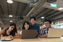 Jeunes gens d'affaires asiatiques travaillant ensemble dans un bureau moderne — Photo de stock