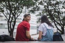 Jovem asiático faculdade estudantes estudando juntos contra campus — Fotografia de Stock