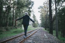 Junge Frau geht und erkundet Bahngleise — Stockfoto