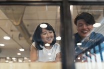 Two young asian people in modern office — Stock Photo
