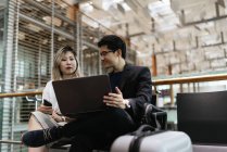 Successful business asian couple together working with laptop in airport — Stock Photo