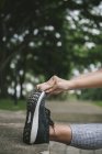 Imagem cortada de jovem mulher desportiva fazendo alongamento no parque — Fotografia de Stock