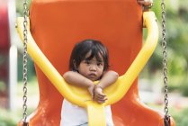 Мила чарівна азіатська маленька дівчинка на гойдалці на дитячому майданчику — стокове фото