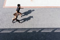 Молодая спортивная пара, бегающая вместе по городской улице — стоковое фото