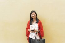Молодая счастливая азиатка с помощью смартфона — стоковое фото