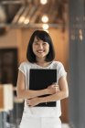 Jeune asiatique femme travailleur dans moderne bureau holding notes — Photo de stock