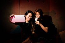 Good girl friends taking selfie in night club — Stock Photo