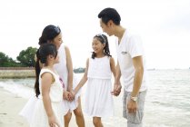 Щаслива азіатська сім'я проводить час разом на пляжі — стокове фото