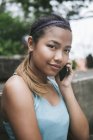 Jovem asiático mulher desportiva usando smartphone — Fotografia de Stock