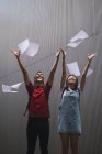 Jeunes étudiants asiatiques de collège jetant du papier dans les airs — Photo de stock