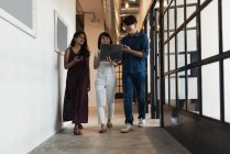 Молодые азиаты за работой с ноутбуком в современном офисе — стоковое фото