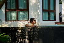Jovem mulher asiática relaxante na piscina — Fotografia de Stock