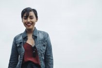 Portrait de jeune attrayant asiatique femme contre gris mur — Photo de stock