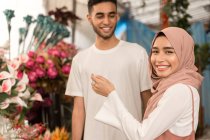 Pareja musulmana joven en floristería - foto de stock