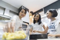 Felice famiglia asiatica che celebra hari raya a casa e cucina in cucina — Foto stock