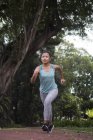 Giovane asiatica donna sportiva in esecuzione nel parco — Foto stock