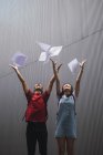 Jeunes étudiants asiatiques de collège jetant du papier dans les airs — Photo de stock