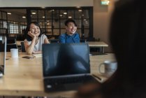 Young asian people at work in modern office — Stock Photo