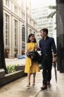 Heureux asiatique jeune couple ensemble marche sur ville rue — Photo de stock