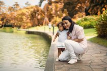 Joven asiático madre con lindo poco hija en parque - foto de stock