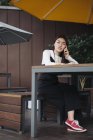 Jolie femme chinoise cheveux longs parler au smartphone dans le café — Photo de stock