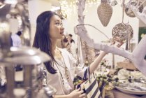 Молода щаслива азіатська жінка в магазині — стокове фото