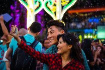 Молода азіатська пара проводить час разом у місті, святкуючи Різдво і приймаючи селфі — стокове фото